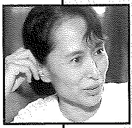 Aung San Suu Kyi, head and shoulders, her hand raised to her chin