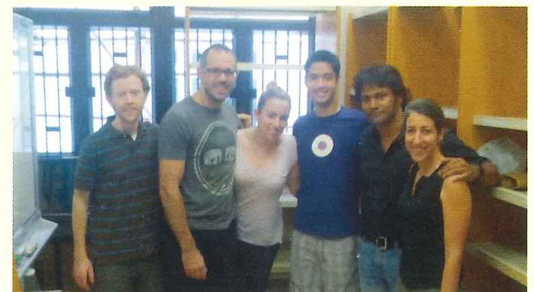 Six volunteers stand together for a photograph in a room at the centre.