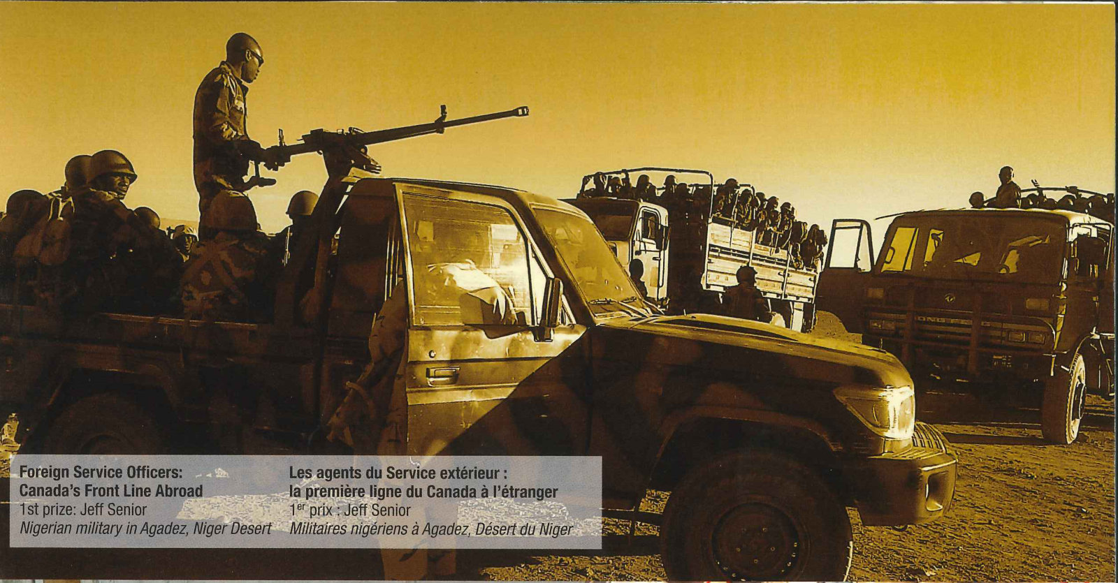 Soldiers on pickup trucks at dusk, one standing behind a mounted machine gun // Des militaires sur des camionnettes au crépuscule, l’un debout derrière une mitrailleuse