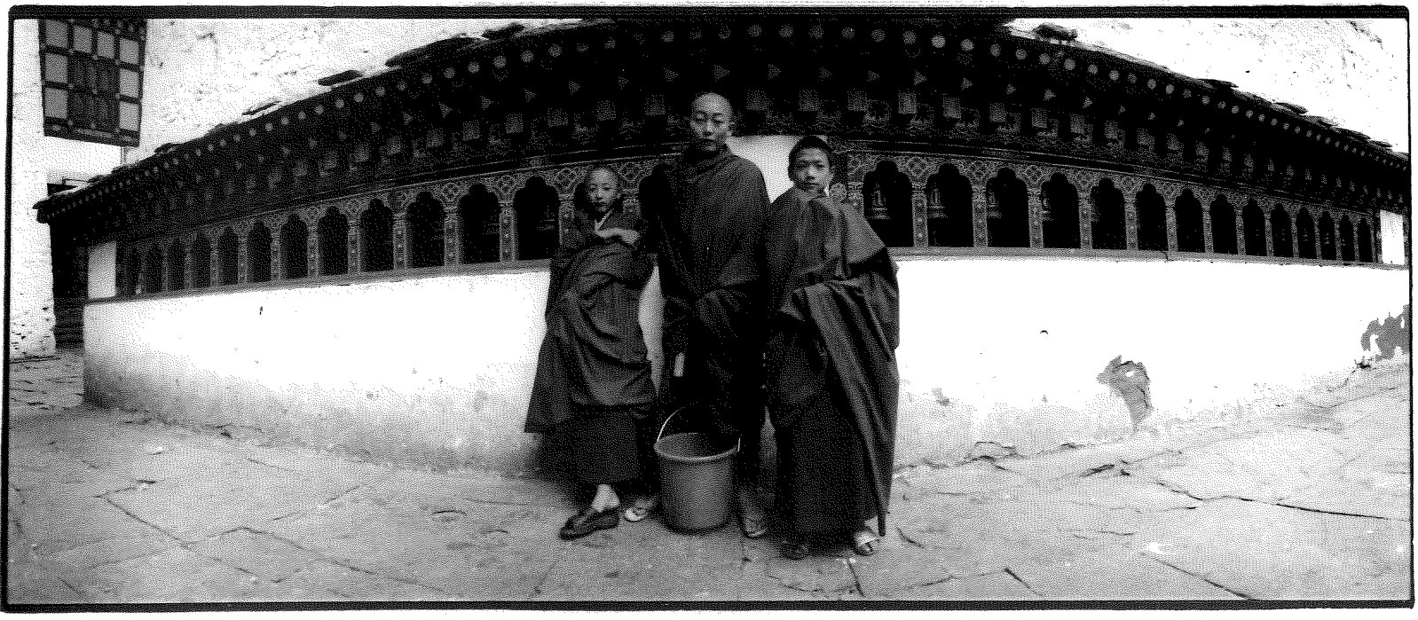 BHUTAN This black and white photo of three monks in Paro was taken with a large panoramic Noblex negative camera in 2001. It has been in several exhibits in Asia and Ottawa and the Scotiabank Contact Photography Festiva! in Toronto. I really loved going to Bhutan, as very few people have the opportunity to go there. I was sent there a second time by the Bhutan embassy in Bangkok to produce an article regarding their health system. It is a beautiful country, and the people are so friendly. Fluttering prayer flags and maroon-robed monks are a common sight, while white-walled monasteries and prayer wheels dominate the landscape.